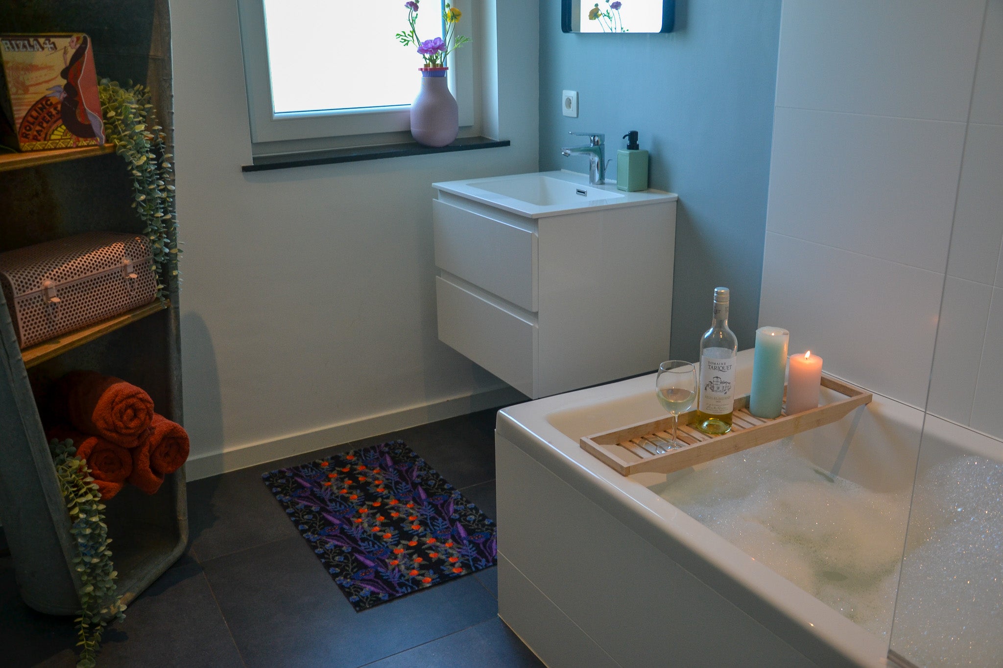 Zachte, waterabsorberende badmat van Studio LilaLine met een gestileerde bessenprint in zwart, blauw en rood – het ontwerp toont organische vormen die speels over de mat verspreid liggen, met een grafische uitstraling en diepe kleuren. De mat voelt comfortabel aan onder de voeten en brengt een stoer, stijlvol accent in de badkamer.