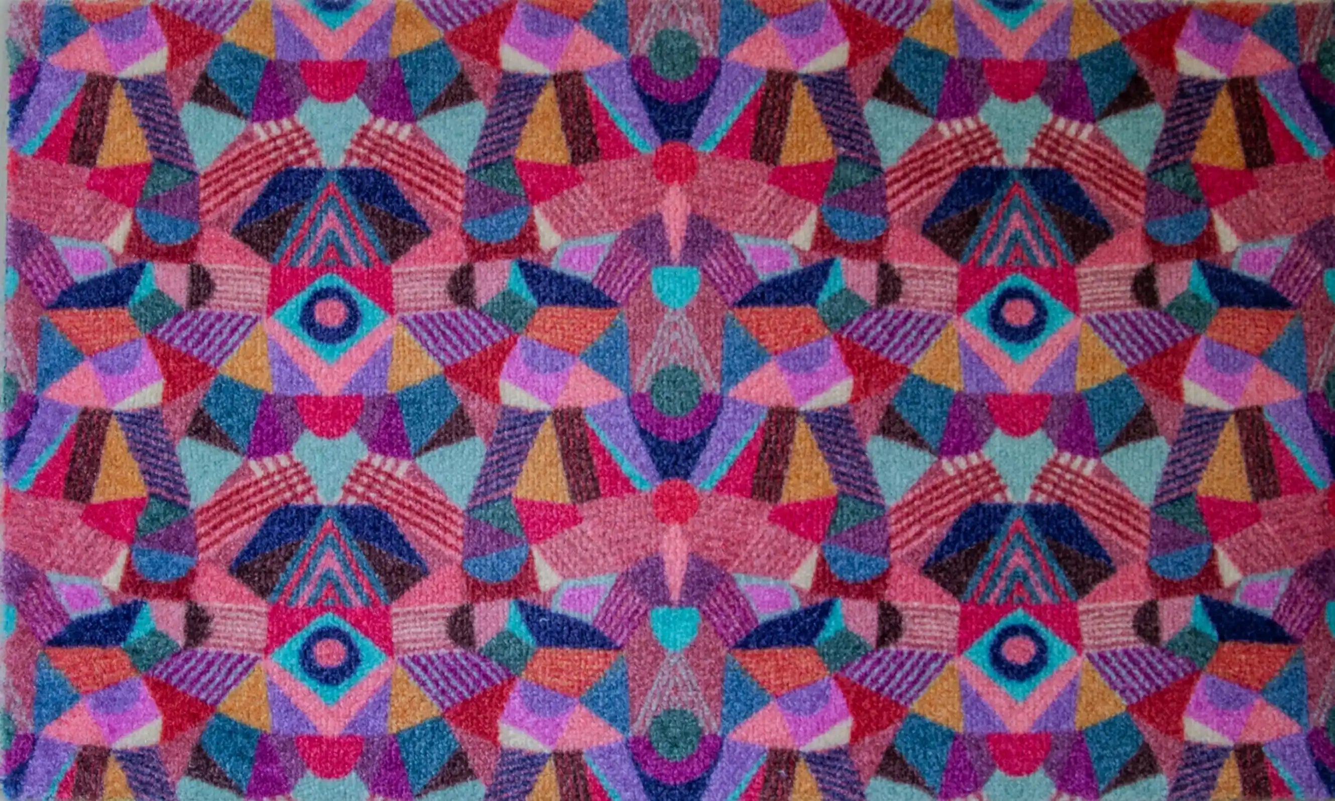 Zachte en goed absorberende badmat van Studio LilaLine met een kleurrijk patroon in roze, rood, groen en blauw – het ontwerp lijkt op de symmetrische patronen van een caleidoscoop, met speelse vormen die in lagen over elkaar draaien. De levendige kleuren maken deze mat een echte blikvanger in de badkamer. Heerlijk zacht voor je voeten na het douchen of badderen.
