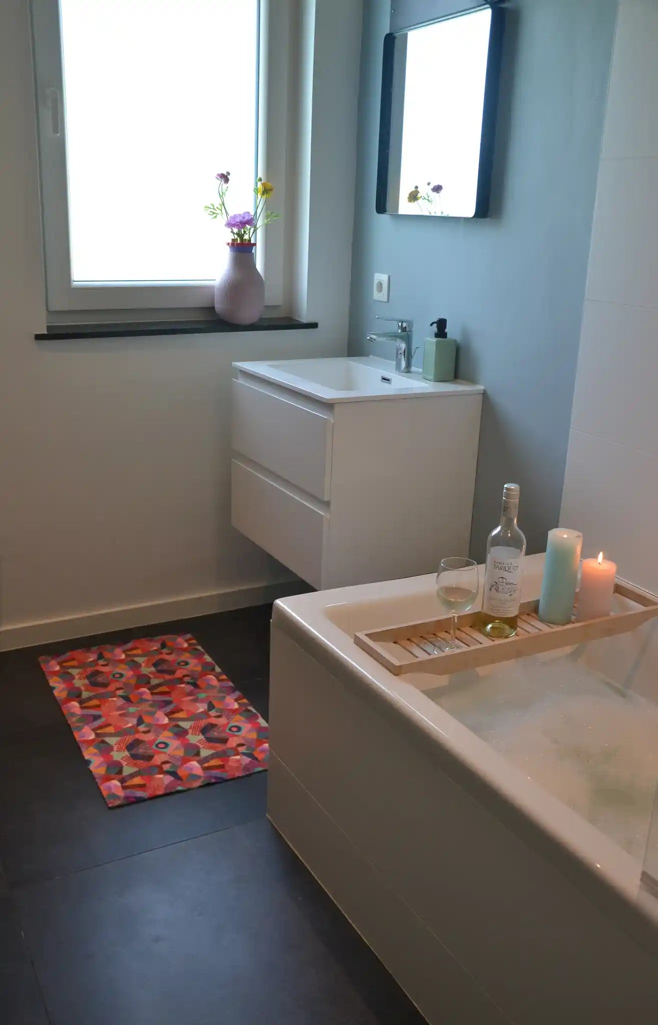 Zachte en goed absorberende badmat van Studio LilaLine met een kleurrijk patroon in roze, rood, groen en blauw – het ontwerp lijkt op de symmetrische patronen van een caleidoscoop, met speelse vormen die in lagen over elkaar draaien. De levendige kleuren maken deze mat een echte blikvanger in de badkamer. Heerlijk zacht voor je voeten na het douchen of badderen.