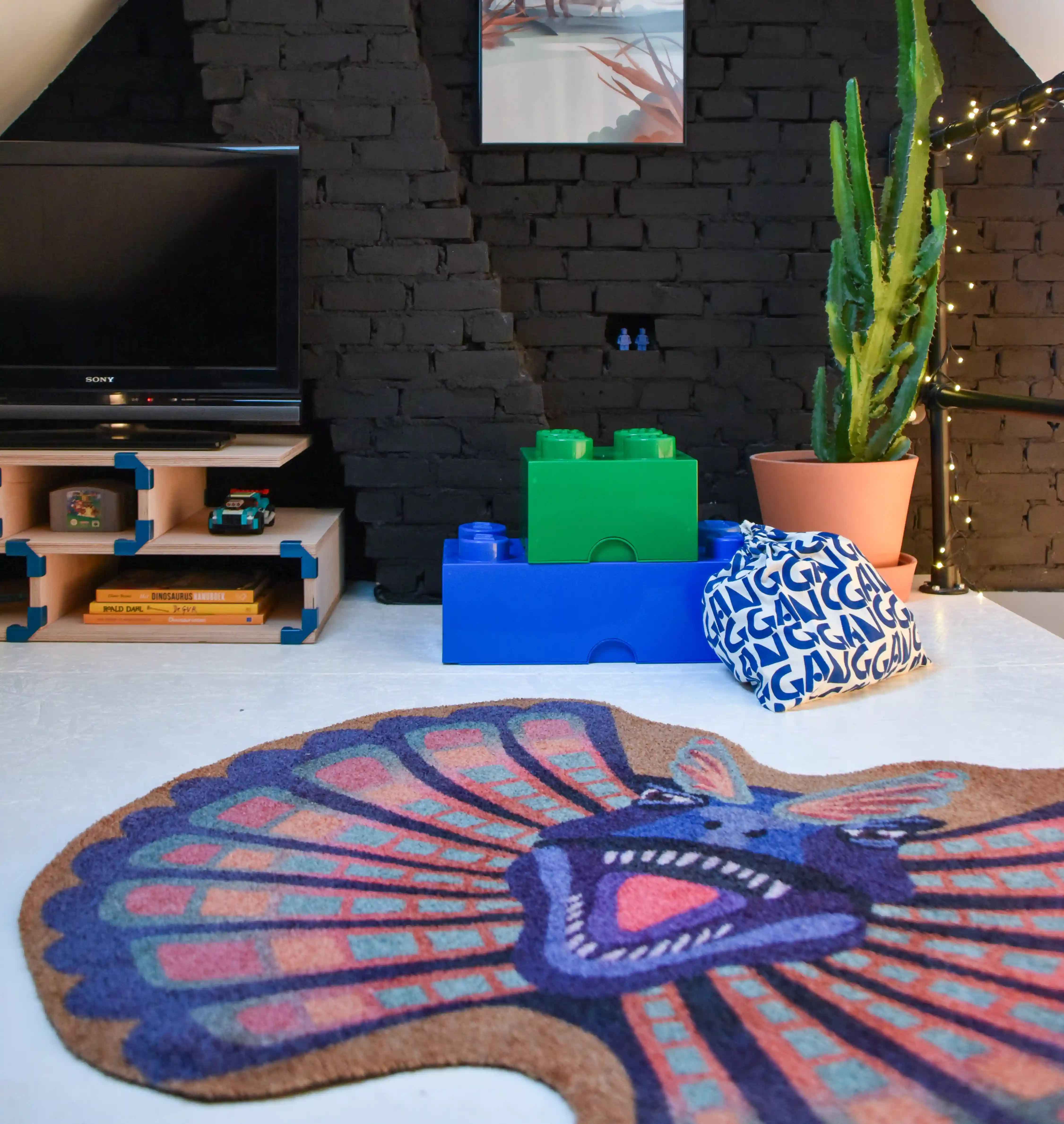 Alt-tekst:
Zacht uitgesneden dierenkleed in de vorm van een dilophosaurus-hoofd van Studio LilaLine – het kleed beeldt de dinosaurus af met zijn opvallende kraag wijd uitgespreid, in tinten van blauw en warm oker. De kraag heeft puntige vormen en een waaierachtige uitstraling, terwijl het gezicht expressief en stoer is. Een fantasierijke en zachte speelplek voor dino-liefhebbers in de kinderkamer.