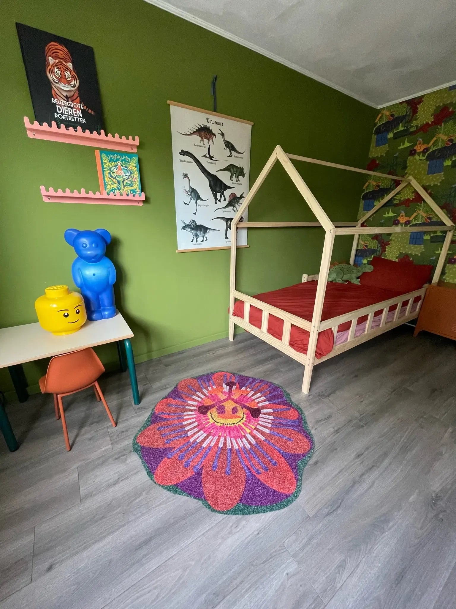 Zacht uitgesneden kleed in de vorm van een passiebloem van Studio LilaLine – dit vloerkleed toont een ronde bloem met uitgesneden bloemblaadjes in warme oranjetinten en diep paars. Het bloemhart is rijk gelaagd en straalt naar buiten, als een zonnige explosie van kleur. De vorm is symmetrisch en organisch, met een zachte structuur die uitnodigt tot spelen of relaxen in een kinderkamer of gezellige hoek.