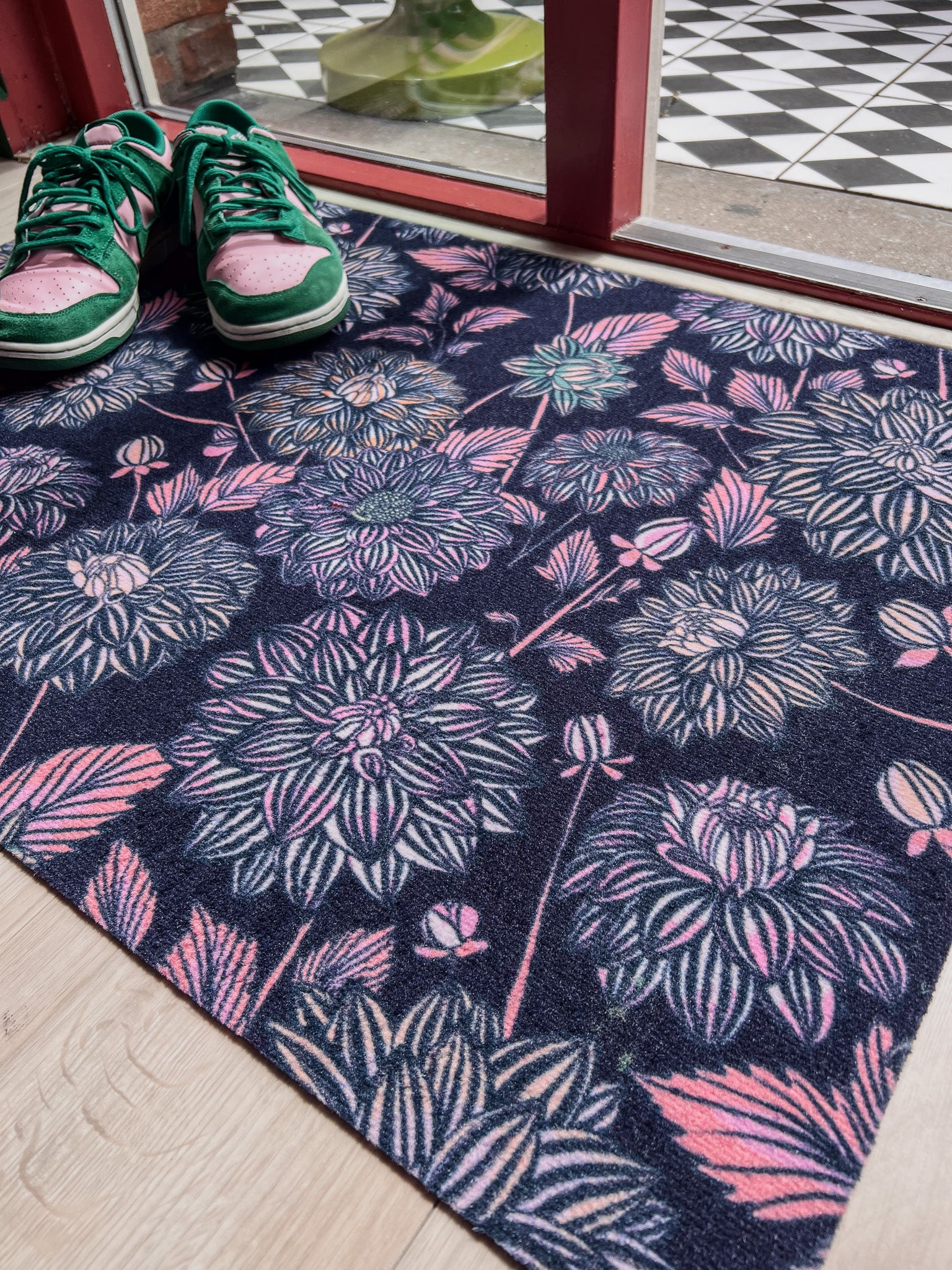 Droogloopmat met dahlia’s in roze en blauwtinten op een diep donkerblauwe basis. Een gelaagde, winterse bloemenprint met een dromerige uitstraling.