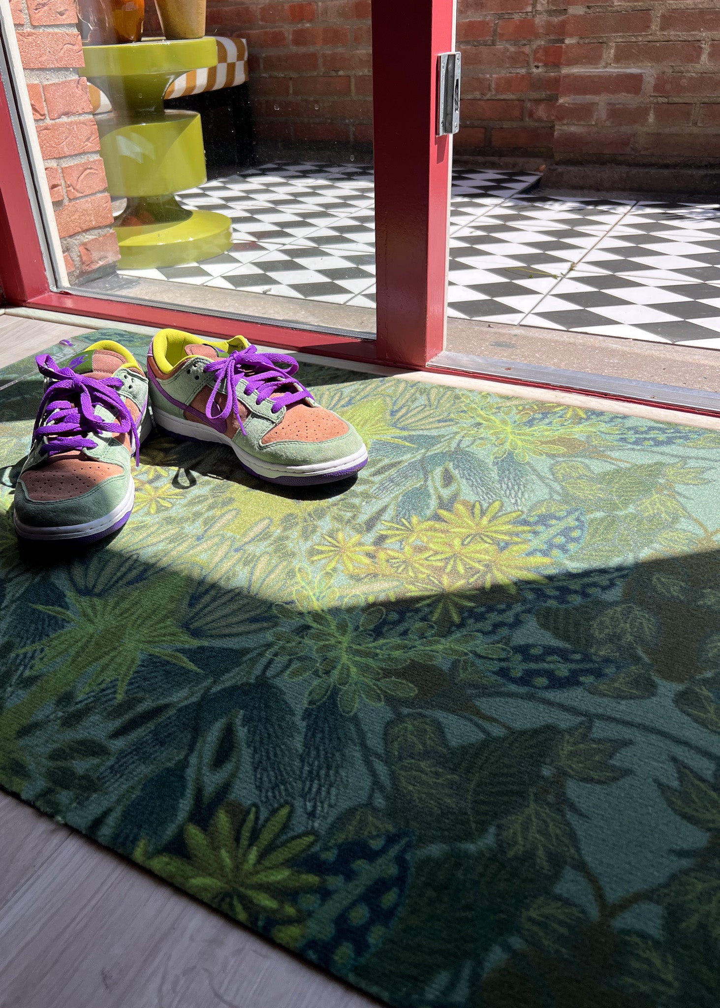 Droogloopmat en deurmat van Studio LilaLine met een print die doet denken aan een dichtbegroeid, fris groen bos – opgebouwd uit allerlei groentinten en abstracte bladerstructuren. De mat straalt rust en natuur uit, en is slijtvast en vochtopnemend. Ideaal om je hal of gang een kalme, organische uitstraling te geven met een vleugje avontuur.