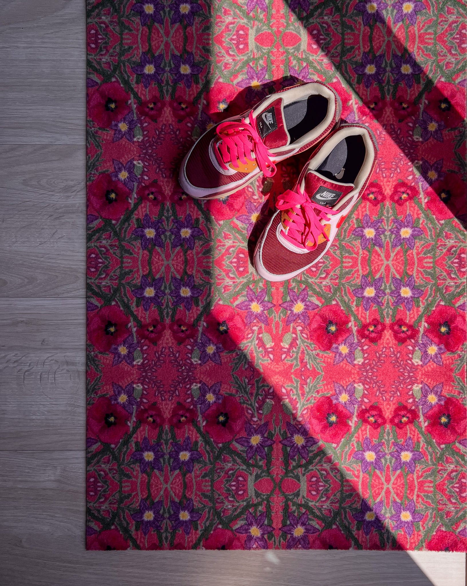Op maat gemaakte droogloopmat van Studio LilaLine met een speelse klaprozenprint in roze en roodtinten – de bloemen lijken te dansen over het oppervlak en geven een vrolijke, zomerse uitstraling. De mat is slijtvast en vochtopnemend, en brengt meteen kleur en karakter in je entree.
