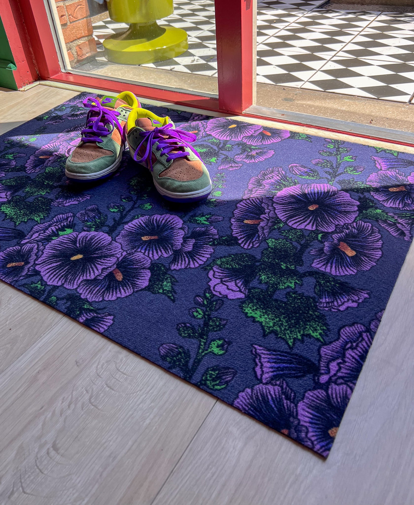Droogloopmat met lila stokrozen op een vergrijsd blauwe achtergrond. Een rustige, zachte winterprint met een vleugje romantiek.