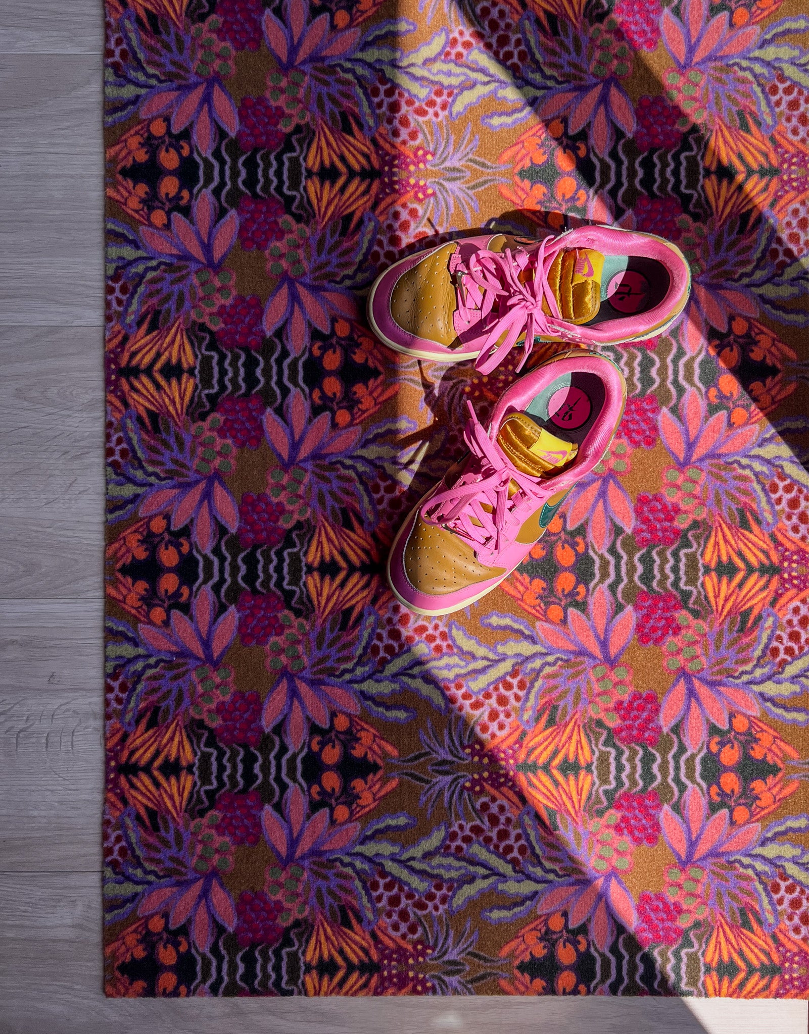 Droogloopmat en deurmat van Studio LilaLine met een uitbundige tropische bloemenprint in warme oranje- en paarstinten – het ontwerp straalt zon, vrolijkheid en zomerse energie uit. De mat is slijtvast, neemt vocht goed op en fleurt elke entree op met kleur en karakter. Perfect voor binnen én beschutte buitenruimtes.