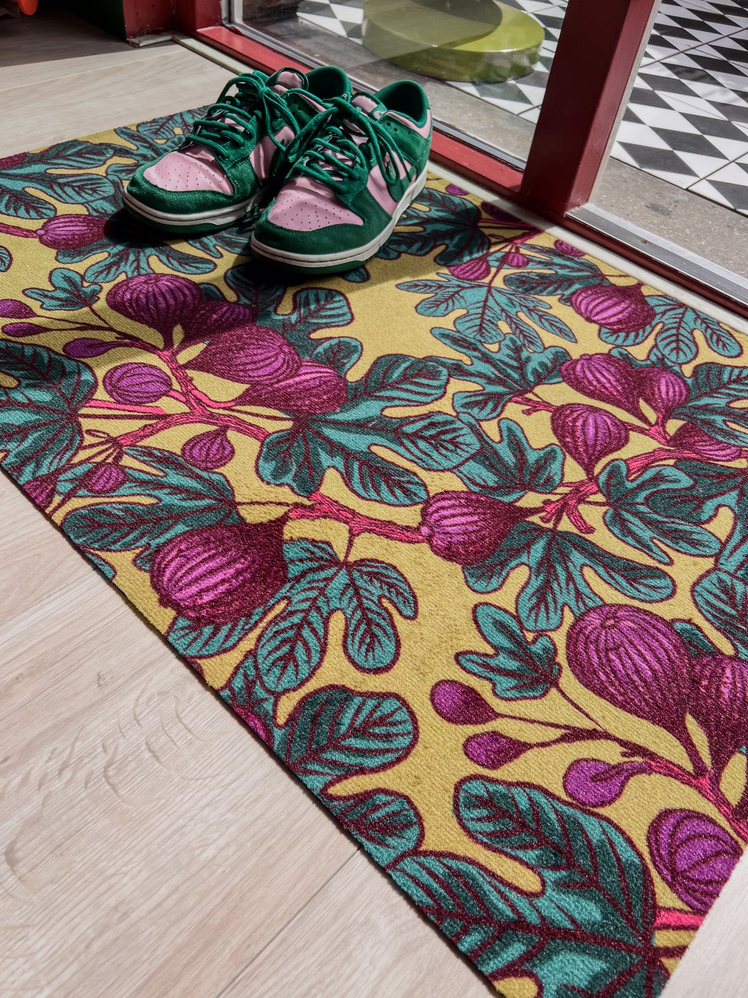 Droogloopmat met vijgenbladprint in okergeel, paars en frisgroen. Een levendige lentemix die zon, kleur en natuur in huis haalt.
