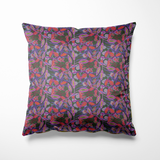 Kussen voor binnen en buiten met een dynamisch patroon van speelse blaadjes en bessen in paars, rood, roze en felgroen, op een donkere, mysterieuze achtergrond. Het ontwerp heeft een retro-hipster vibe met een vleugje psychedelische flair, perfect voor wie houdt van kleur, contrast en karakter. Gemaakt van stevig, waterafstotend materiaal, geschikt voor zowel je interieur als je tuinbank.