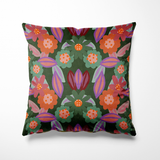 Kussen voor binnen en buiten met een speels bloemenpatroon in warme tinten als oranje, aubergine, zachtgroen en paars. De bloemen hebben iets weg van vrolijke koekjes met glazuur, wat het ontwerp een luchtige en vrolijke uitstraling geeft. De achtergrond is donkergroen en zorgt voor een mooi contrast. Gemaakt van stevige, waterafstotende stof, perfect voor zowel binnen op de bank als buiten in de tuin of op het balkon.