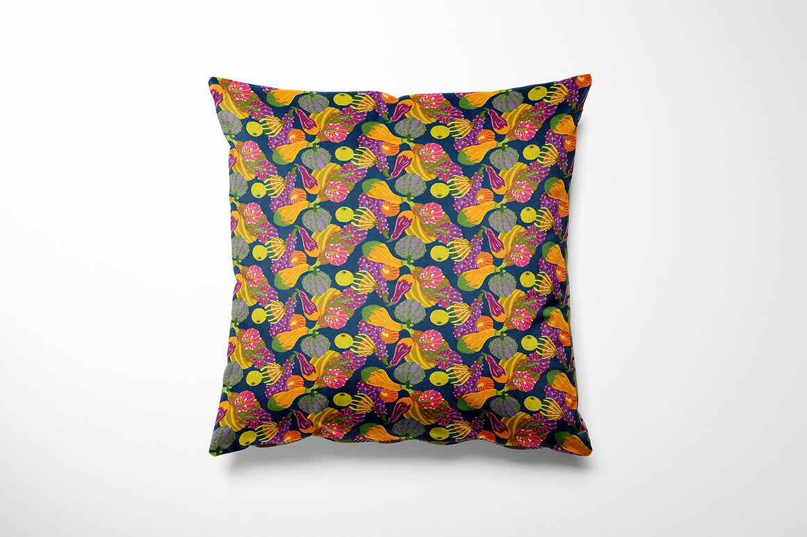 Vierkant binnen- en buitenkussen met een speelse pompoenprint in oranje, limegroen, roze, paars en geel op een donkerblauwe achtergrond. Het patroon bestaat uit herhalende vormen van sierpompoenen en bloemen, die zorgen voor een kleurrijk herfstgevoel met een vrolijke twist – perfect voor op de bank of je tuinset.