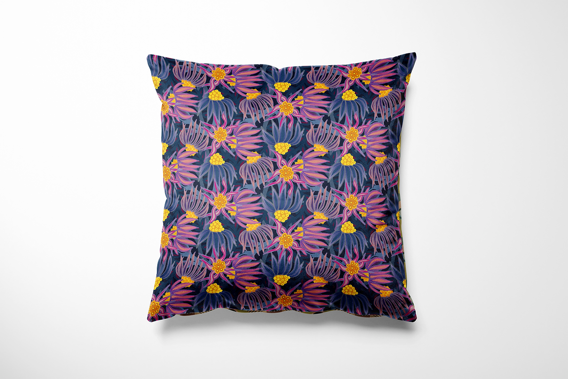 Vierkant binnen- en buitenkussen met een speelse bloemenprint in paars, roze en lila op een diepblauwe achtergrond. Heldere accenten in mosterdgeel geven het ontwerp extra pit. De print toont fantasiebloemen met lange blaadjes die in alle richtingen dansen, perfect voor een vrolijke en kleurrijke sfeer op je bank of tuinstoel.