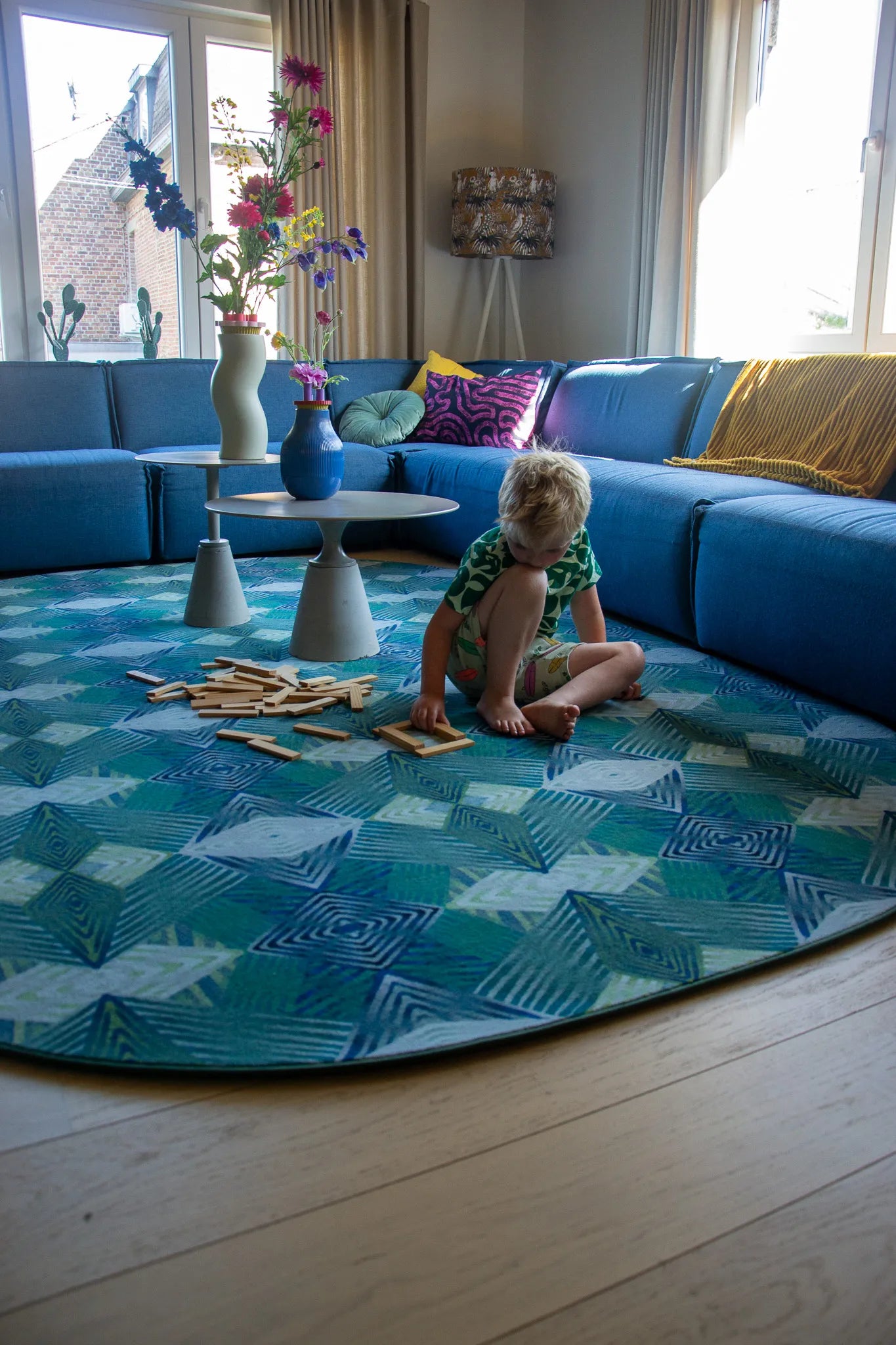 Luxe vloerkleed Diamond Petrol van Studio LilaLine met een grafisch diamantpatroon in diepe groentinten en petrolblauw – het kleed voelt zacht en stevig aan, en het patroon bestaat uit overlappende lijnen die doen denken aan edelstenen, strak en toch speels. Ideaal als opvallend middelpunt in een modern interieur.