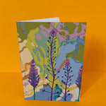 Alt-tekst:
Dubbelgevouwen luxe A5-kaart van Studio LilaLine met op de voorkant een elegante illustratie van vingerhoedskruid in tinten groen, blauw en paars – de bloemstengel buigt sierlijk omlaag, met klokvormige bloemen die als een ketting van belletjes naar beneden hangen. De uitstraling is kalm, botanisch en een tikkeltje magisch. De binnenkant is blanco en biedt volop ruimte voor een liefdevolle of bemoedigende boodschap.