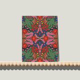 Enkele A6-kaart van Studio LilaLine met een symmetrische bloemenprint op de voorkant – het ontwerp bestaat uit spiegelende bloemvormen in groen, roze en blauw. De compositie voelt bijna als een vlinder of een inktvlektest: perfect in balans, met sierlijke lijnen die naar buiten toe uitwaaieren. De kleuren zorgen voor een frisse, dromerige uitstraling. De achterkant is leeg en klaar voor een handgeschreven boodschap.