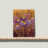 Enkele A6-kaart van Studio LilaLine met een bloemrijke print op de voorkant – het ontwerp toont een gestileerde Perzische margriet in diepe okertinten en paars. De bloem straalt symmetrie uit, met een grafische uitstraling en verfijnde details die doen denken aan sierlijke patronen uit textiel of keramiek. De kleuren zijn warm en rijk. De achterkant biedt ruimte voor een handgeschreven boodschap.