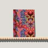 Enkele A6-kaart van Studio LilaLine met een retro bloemenprint op de voorkant – het ontwerp toont gestileerde bloemen in een speelse compositie van blauw, oranje en paars. De vormen zijn rond, grof en grafisch, met een duidelijke knipoog naar de jaren 60 en 70. De kleuren zijn krachtig en vrolijk, perfect voor een opbeurende boodschap. De achterkant is blanco en klaar om op te schrijven.