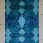 Zachte, waterabsorberende badmat van Studio LilaLine met een grafisch diamantpatroon in tinten petrol, blauw en groen – het ontwerp bestaat uit ritmische lijnen en geometrische vormen die samen een kalme, frisse uitstraling geven. De mat voelt aangenaam onder blote voeten en brengt kleur en stijl in de badkamer.