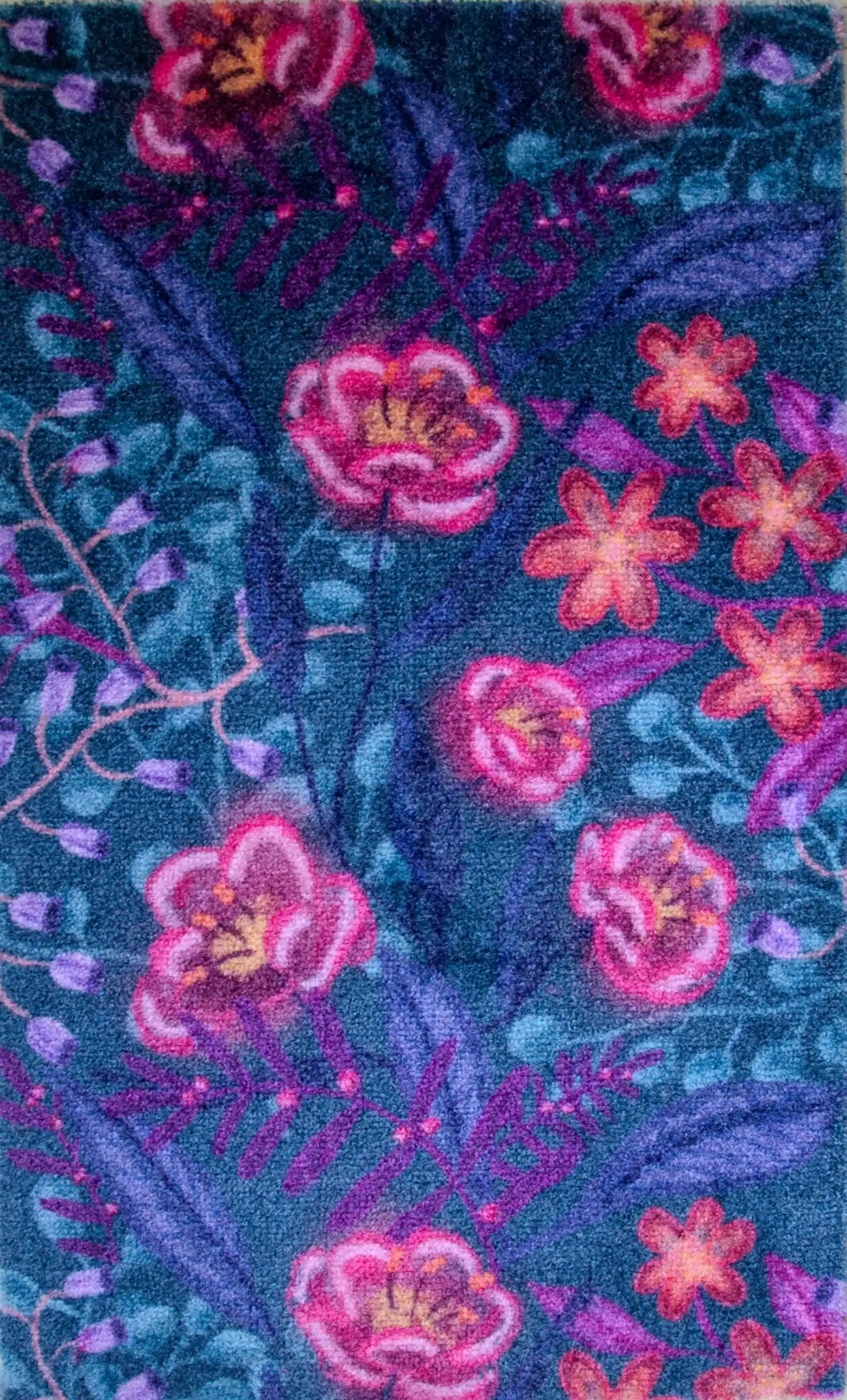 Zachte, waterabsorberende badmat van Studio LilaLine met een dromerige bloemenprint in diepe petroltinten, gecombineerd met accenten van roze en paars – het ontwerp straalt rust en elegantie uit, met sierlijke vormen die lijken te zweven over het oppervlak. De mat voelt heerlijk zacht aan en brengt een stijlvolle, ontspannen sfeer in de badkamer.