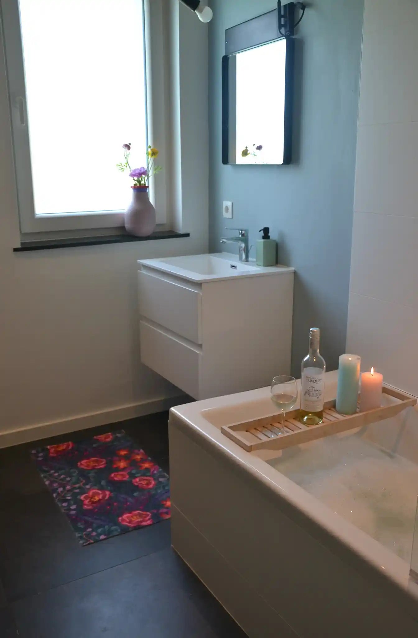 Zachte, waterabsorberende badmat van Studio LilaLine met een dromerige bloemenprint in diepe petroltinten, gecombineerd met accenten van roze en paars – het ontwerp straalt rust en elegantie uit, met sierlijke vormen die lijken te zweven over het oppervlak. De mat voelt heerlijk zacht aan en brengt een stijlvolle, ontspannen sfeer in de badkamer.