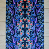 Zachte, waterabsorberende badmat van Studio LilaLine met een gestileerde bessenprint in zwart, blauw en rood – het ontwerp toont organische vormen die speels over de mat verspreid liggen, met een grafische uitstraling en diepe kleuren. De mat voelt comfortabel aan onder de voeten en brengt een stoer, stijlvol accent in de badkamer.
