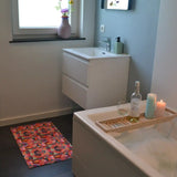 Zachte en goed absorberende badmat van Studio LilaLine met een kleurrijk patroon in roze, rood, groen en blauw – het ontwerp lijkt op de symmetrische patronen van een caleidoscoop, met speelse vormen die in lagen over elkaar draaien. De levendige kleuren maken deze mat een echte blikvanger in de badkamer. Heerlijk zacht voor je voeten na het douchen of badderen.