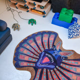 Alt-tekst:
Zacht uitgesneden dierenkleed in de vorm van een dilophosaurus-hoofd van Studio LilaLine – het kleed beeldt de dinosaurus af met zijn opvallende kraag wijd uitgespreid, in tinten van blauw en warm oker. De kraag heeft puntige vormen en een waaierachtige uitstraling, terwijl het gezicht expressief en stoer is. Een fantasierijke en zachte speelplek voor dino-liefhebbers in de kinderkamer.