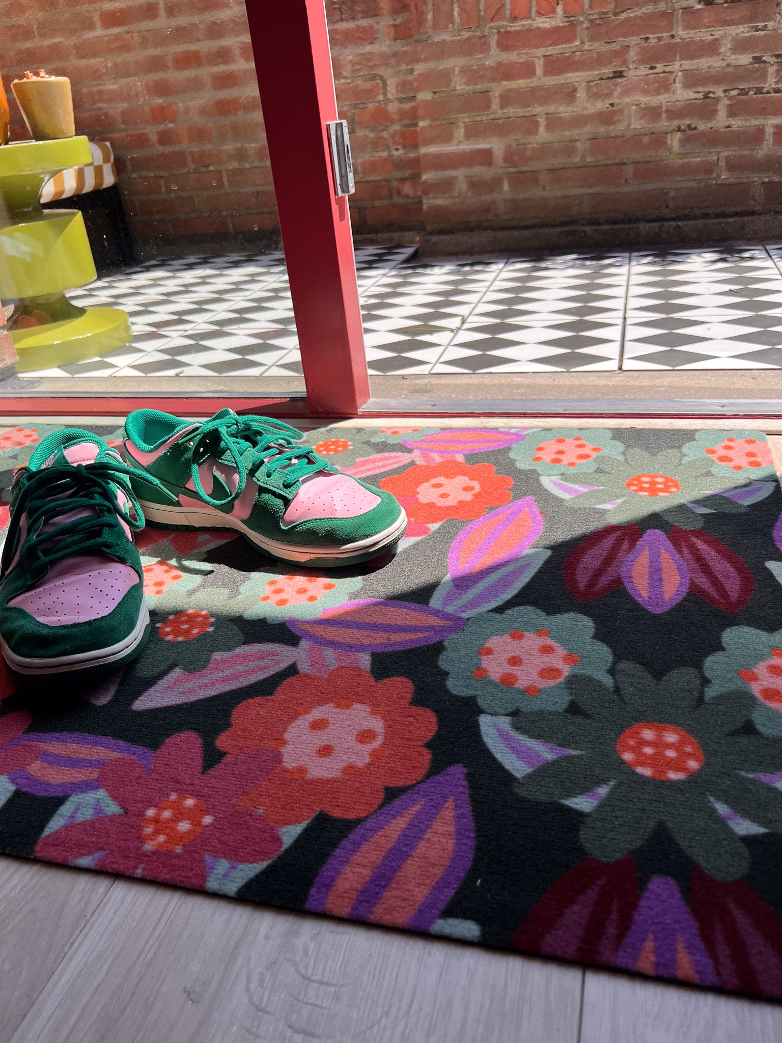 Droogloopmat en deurmat van Studio LilaLine met een speelse bloemvorm in tinten roze, oranje en groen – het ontwerp doet denken aan een vrolijk uitgestoken koekje met een knipoog naar retro bloemmotieven. De mat is slijtvast, neemt goed vocht op en zorgt voor een kleurrijke en uitnodigende entree, zowel praktisch als decoratief.