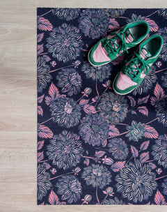 Droogloopmat met dahlia’s in roze en blauwtinten op een diep donkerblauwe basis. Een gelaagde, winterse bloemenprint met een dromerige uitstraling.
