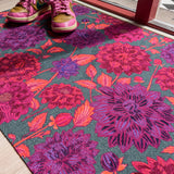 Droogloopmat met grote dahlia's in paars, roze en rood op een diepe petrolkleur. Een uitbundige bloemenprint vol zomerse energie.
