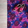 Droogloopmat met roze klaprozen die oplichten tegen een felblauwe achtergrond. Een verrassende winterprint vol kleur en optimisme.