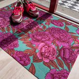Droogloopmat met roze pioenrozen op een frisse petrolgroene achtergrond. Een zachte, lenteachtige bloemenprint die je hal laat opbloeien.
