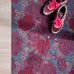 Droogloopmat met oudroze en rode pioenrozen op een vergrijsd blauwe ondergrond. Een elegante, winterse bloemenprint die rust en stijl brengt.