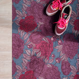 Droogloopmat met oudroze en rode pioenrozen op een vergrijsd blauwe ondergrond. Een elegante, winterse bloemenprint die rust en stijl brengt.