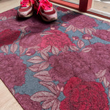Droogloopmat met oudroze en rode pioenrozen op een vergrijsd blauwe ondergrond. Een elegante, winterse bloemenprint die rust en stijl brengt.