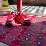 Op maat gemaakte droogloopmat van Studio LilaLine met een speelse klaprozenprint in roze en roodtinten – de bloemen lijken te dansen over het oppervlak en geven een vrolijke, zomerse uitstraling. De mat is slijtvast en vochtopnemend, en brengt meteen kleur en karakter in je entree.
