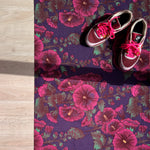 Droogloopmat met roze stokrozen op een diepe paarse ondergrond. Een rijke, zomerse print vol charme en contrast.