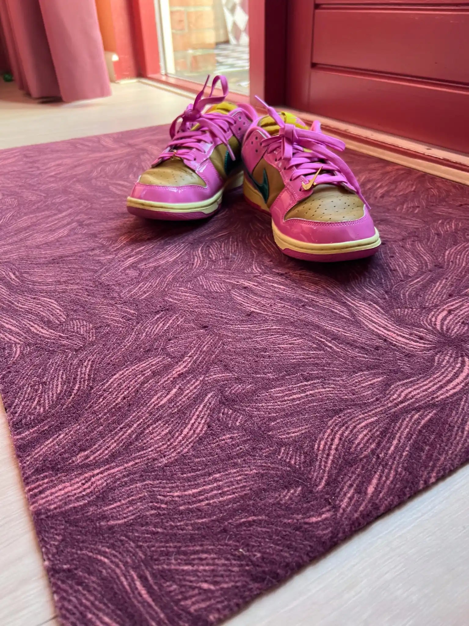 Op maat gemaakte droogloopmat Swirl in donkere terratinten met vloeiend lijnenspel – warme design deurmat voor binnen van Studio LilaLine