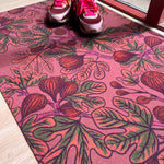 Droogloopmat met vijgenbladeren in warme oranje- en groentinten op een mauve basis. Een aardse herfstprint vol rust en rijkdom.