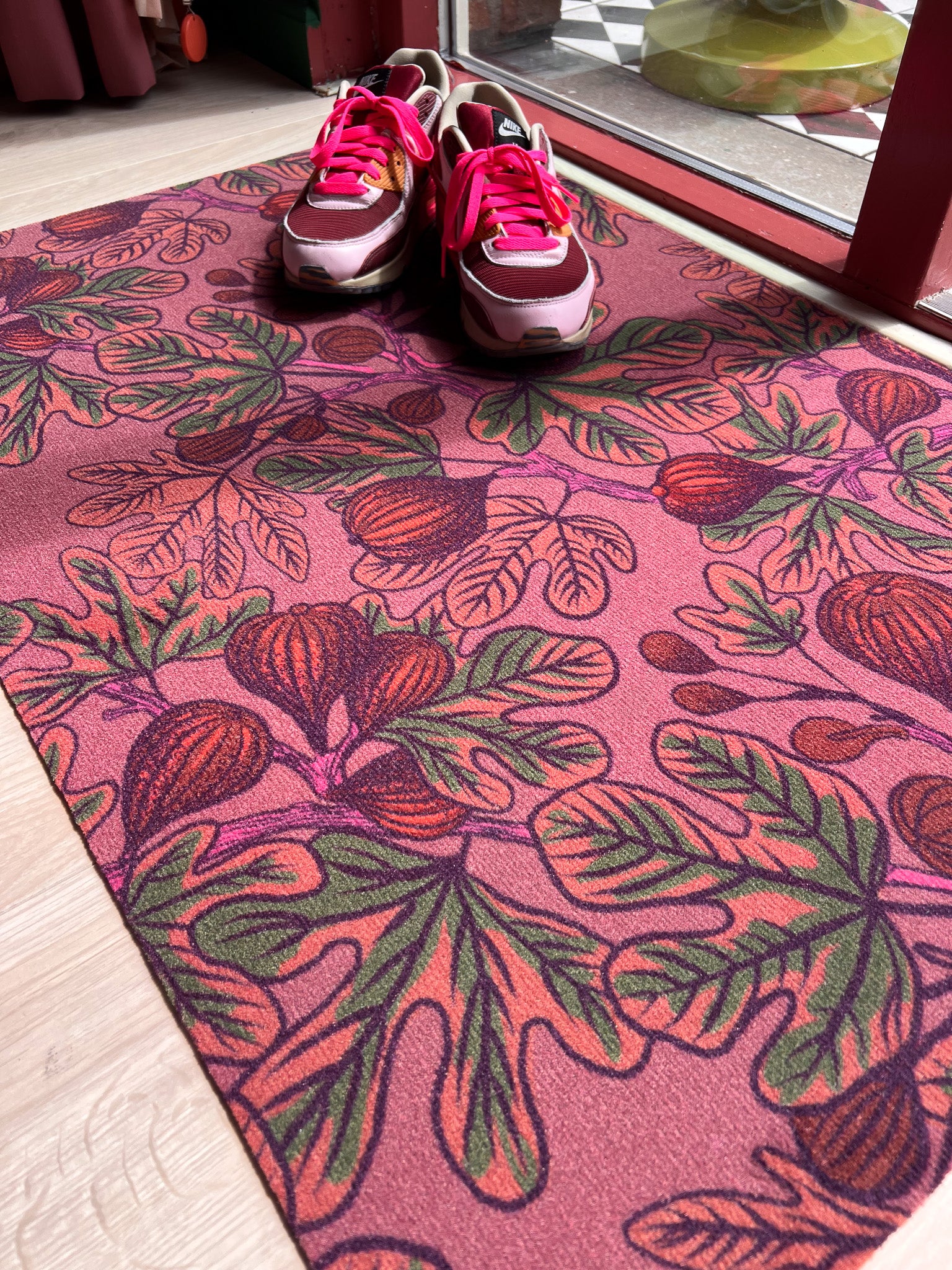 Droogloopmat met vijgenbladeren in warme oranje- en groentinten op een mauve basis. Een aardse herfstprint vol rust en rijkdom.