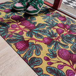 Droogloopmat met vijgenbladprint in okergeel, paars en frisgroen. Een levendige lentemix die zon, kleur en natuur in huis haalt.