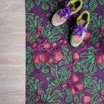 Droogloopmat met vijgenbladmotief in mauve met accenten van donkerpaars en donkergroen. Een diepe, zomerse print met mediterrane warmte.