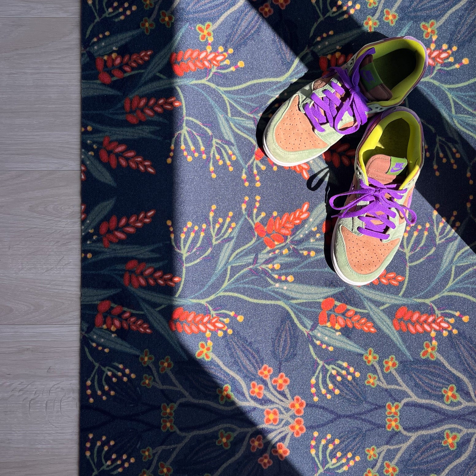 Op maat gemaakte droogloopmat van Studio LilaLine met een sierlijk patroon geïnspireerd op bloeiende blauwe regen – uitgevoerd in diepe petroltinten met verfijnde bloemvormen die als een waterval over de mat lijken te hangen. De print heeft een rustige, elegante uitstraling. De mat is slijtvast, vochtopnemend en perfect voor een stijlvolle entree.