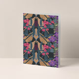 Dubbelgevouwen A6-kaart van Studio LilaLine met op de voorkant een dromerige illustratie van orchideeën – de bloemen zijn uitgevoerd in zachte tinten groen, roze en paars, met sierlijke vormen en vloeiende lijnen. De compositie voelt rustig en elegant aan, als een stil moment in een tropische kas. De binnenkant is blanco en klaar voor een persoonlijke boodschap.
