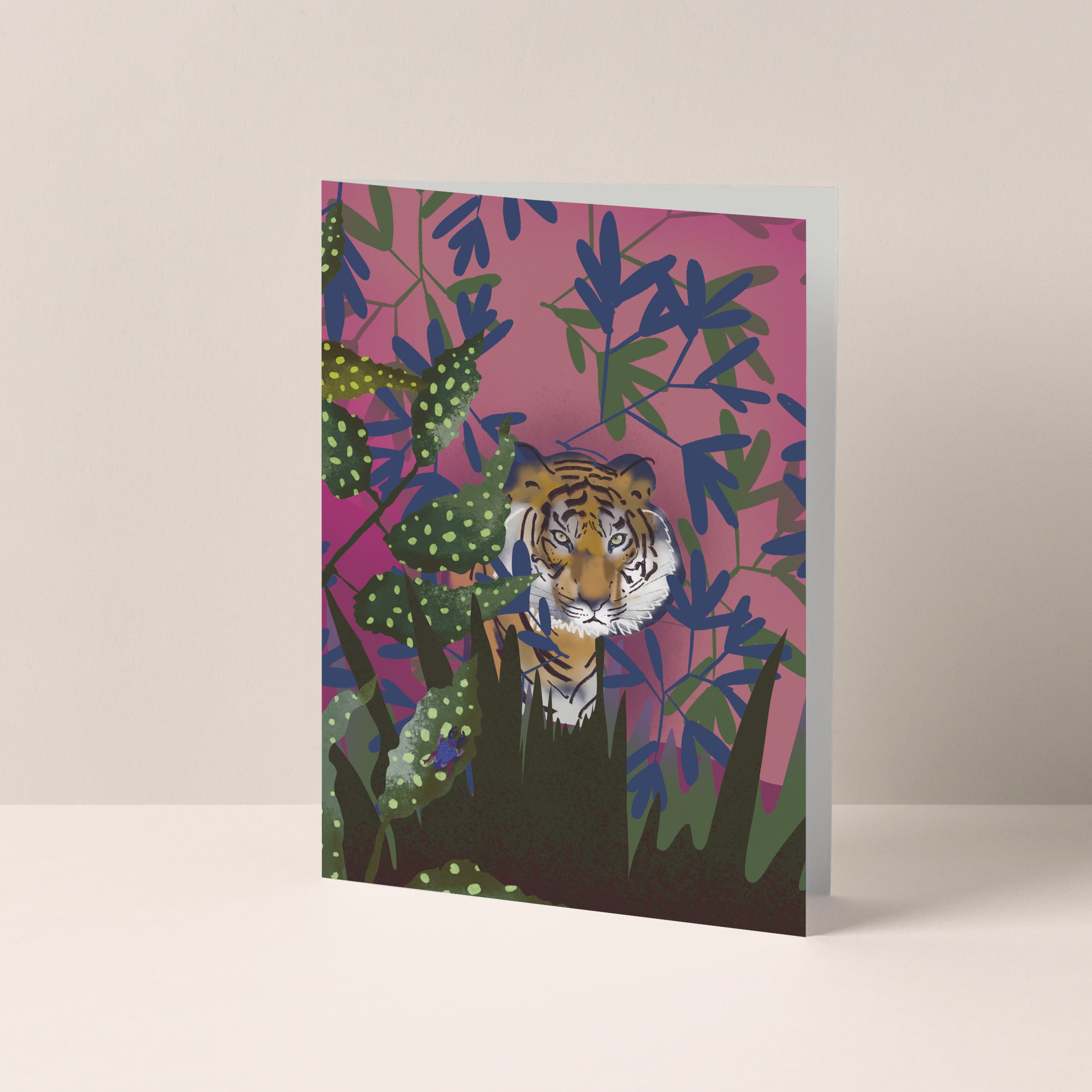 Dubbelgevouwen A6-kaart van Studio LilaLine met op de voorkant een illustratie van een tijger op een roze achtergrond, omringd door groene planten – de tijger kijkt zelfverzekerd en sierlijk vooruit, met vloeiende strepen en een ontspannen houding. De combinatie van de zachte achtergrond en het stoere dier zorgt voor een krachtig maar vriendelijk beeld. De binnenkant is blanco en geschikt voor een persoonlijke boodschap.
