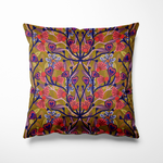 Vierkant binnen- en buitenkussen met een speels, symmetrisch bloemenpatroon in roze, rood en paars met hartvormige details in donkerblauw. De print staat op een mosterdgele achtergrond met olijfgroene accenten, wat zorgt voor een retro en funky uitstraling die elke tuinset of bank direct opvrolijkt.
