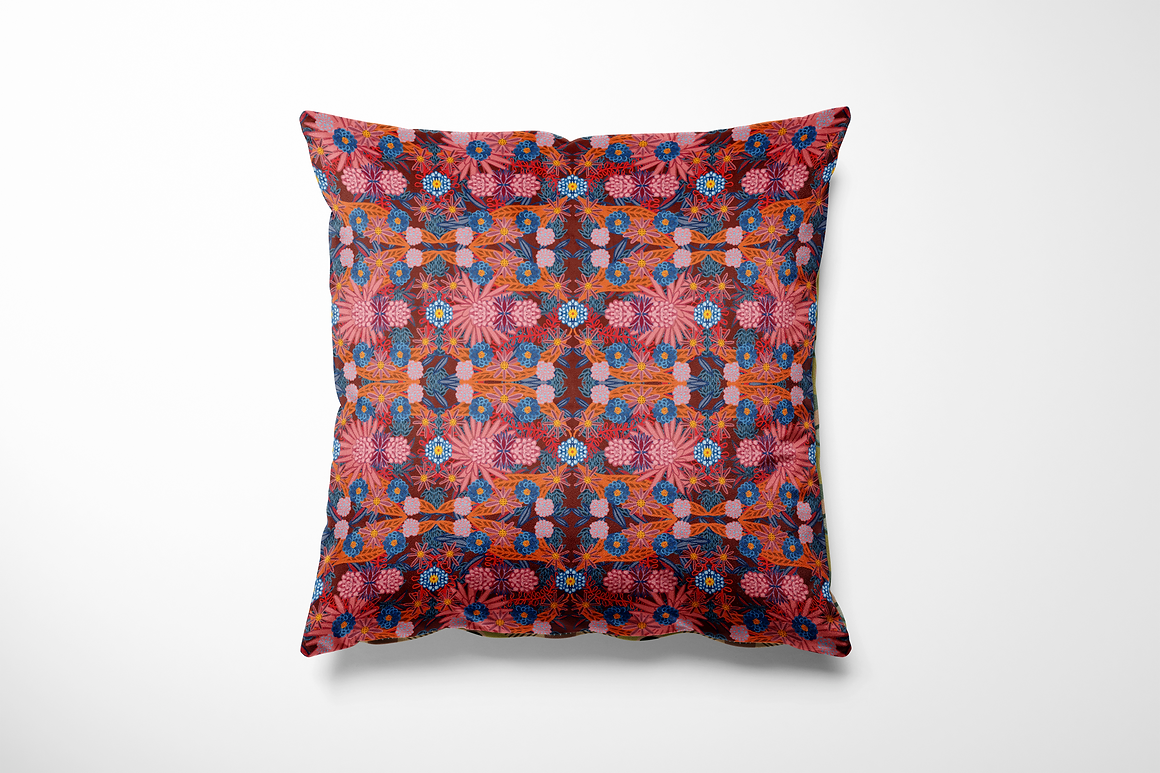 Kussen voor binnen en buiten met een kleurrijke bloemenprint in warme tinten rood, roze en oranje, aangevuld met accenten van kobaltblauw en zonnig geel. De print is rijk en gedetailleerd, als een liefdesexplosie in bloei. Het patroon is symmetrisch opgebouwd en voelt feestelijk, speels en toch gebalanceerd. Gemaakt van stevige stof die geschikt is voor zowel binnen op de bank als buiten op je loungeset.