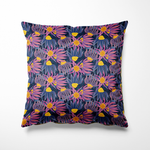Vierkant binnen- en buitenkussen met een speelse bloemenprint in paars, roze en lila op een diepblauwe achtergrond. Heldere accenten in mosterdgeel geven het ontwerp extra pit. De print toont fantasiebloemen met lange blaadjes die in alle richtingen dansen, perfect voor een vrolijke en kleurrijke sfeer op je bank of tuinstoel.