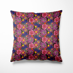 Kussen voor binnen en buiten met een romantische bloemenprint in diepe kleuren. Op een warme roestrode achtergrond bloeien rozen in roze en fuchsia, afgewisseld met bloemen in donkerblauw, zacht lila en felgeel. Dit kleurrijke patroon geeft een zwoele, dromerige sfeer aan je tuin of interieur. Gemaakt van waterafstotende buitenstof – dus ideaal voor binnen én buiten loungen.