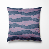Kussen voor binnen en buiten met een golvend lijnenspel in diepblauw en paarsroze tinten. De abstracte print doet denken aan zee of landschap in beweging en geeft een rustige, moderne uitstraling aan je interieur of tuinmeubel. Gemaakt van sterke buitenstof – perfect voor binnen én buiten loungen.