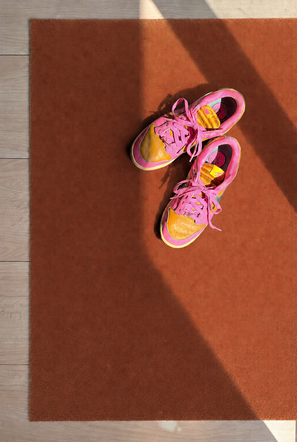 Toastkleurige deurmat met Nike sneakers